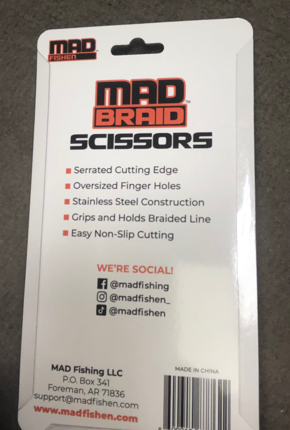 Back of the Mad Braid Scissors packaging, listing key features such as serrated cutting edge, non-slip grip, and stainless steel design, along with MadFishen social media details and contact information.