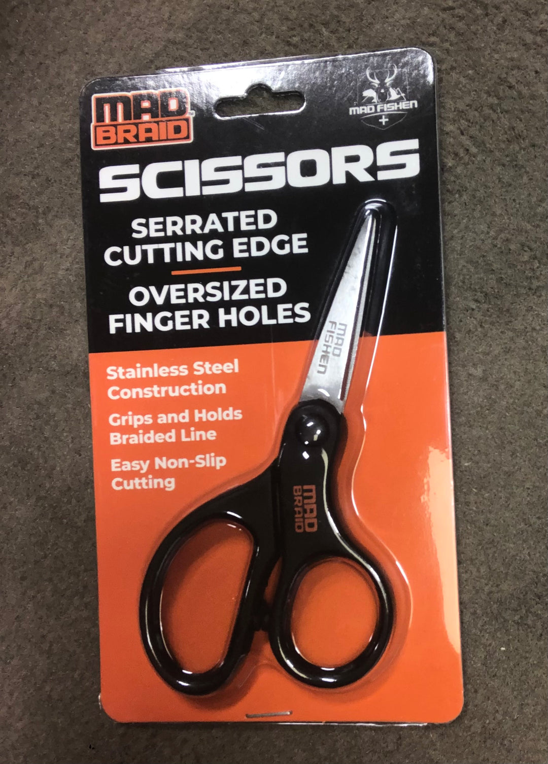 Mad Braid Scissors in original packaging, featuring a serrated cutting edge, oversized finger holes, and stainless steel construction for precise and easy cutting of braided fishing line.